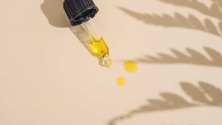 a dropper bottle filled with yellow liquid sitting on top of a table